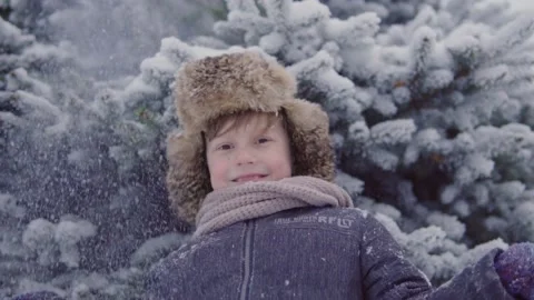 A boy stands under a tree and snow falls on him Stock-Footage 144728508