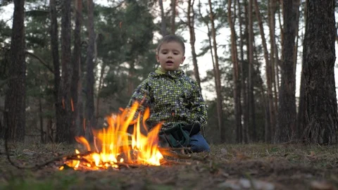 Boy staring at fireplace. Arson background. Beautiful kid warming up at the fire Stock Footage 106537791