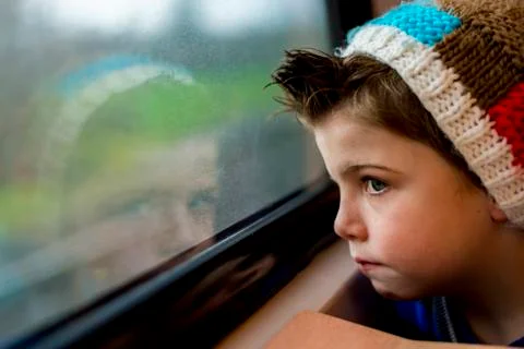 Boy staring through window Stock Photos