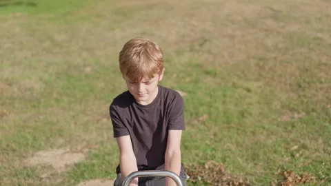 A Boy Starts Feeling Sick on a Seesaw 스톡 동영상 345711159