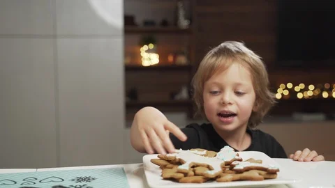 Boy stealing a cookie while is mother is not watching Stock Footage 99627880