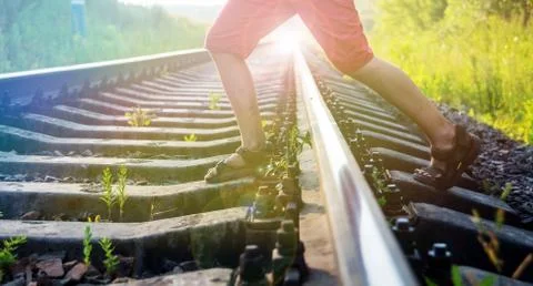 Boy steps over the rails Stock Photos