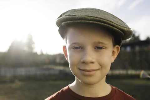 Boy stood outside at sunset with a flat cap Stock Photos