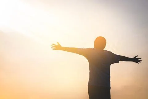 The boy stood spreading both arms in the morning. Happy New Day. .silhouette 库存照片