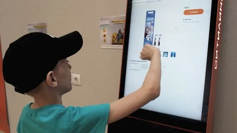 The boy in the store clicks on the touch screen Stock Footage 201837414