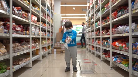 The boy in the store puts on gloves. A child in a mask and gloves. Selects a Stock Footage 129324998