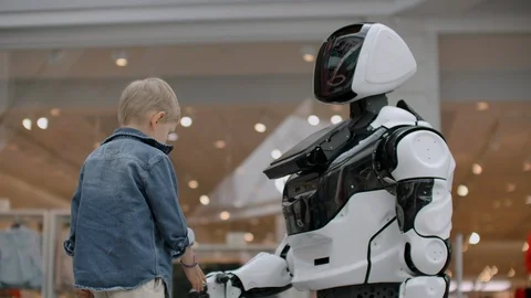 The boy stretches out his hand to the robot for a handshake. Stock Footage