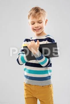 Boy in striped pullover with tablet pc computer Stock Photos