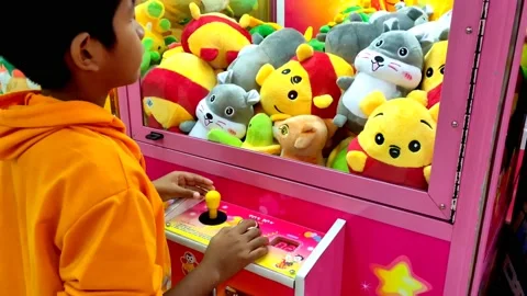 Boy struggled to use the doll claw machine. 스톡 동영상 230341439
