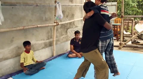 Boy struggles as another practices a take-down on him, practicing jiu jitsu Stock Footage 58458318