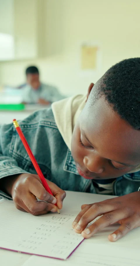 Boy, student and writing in classroom with notebook for math quiz, knowledge or Stock Footage 321873605