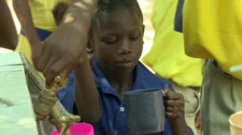 BOY STUDENT DRINKS WATER FROM BLUE CUP Stock Footage 59865199