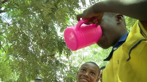 BOY STUDENT DRINKS WATER FROM PINK CUP Stock Footage 59865157