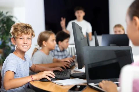 Boy student learning to work on computer in classroom Foto stock