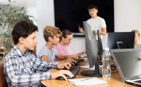 Boy student learning to work on computer in classroom Foto stock