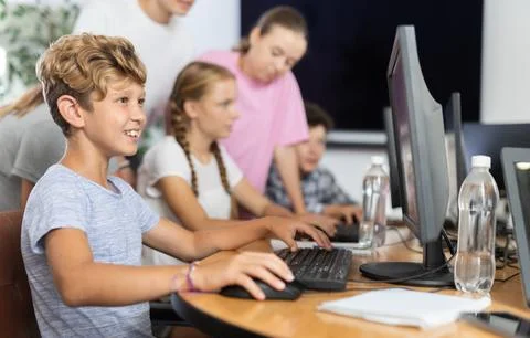 Boy student learning to work on computer in classroom Foto stock