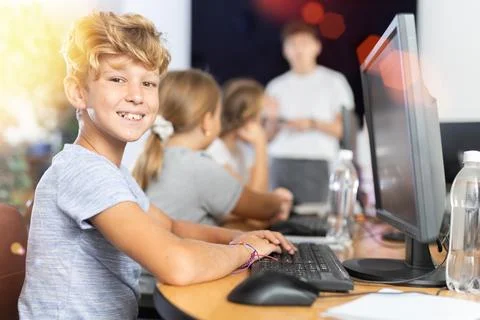 Boy student learning to work on computer in classroom Foto stock