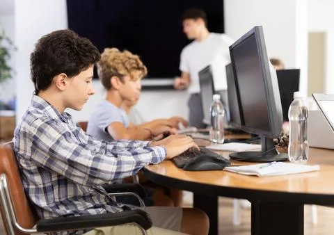 Boy student learning to work on computer in classroom Foto stock
