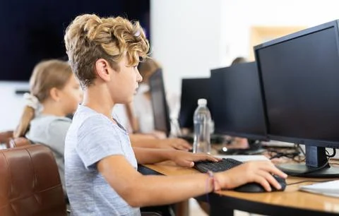 Boy student learning to work on computer in classroom 스톡 사진