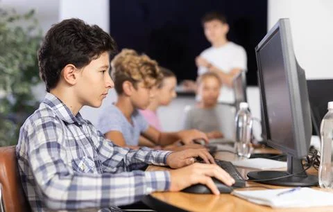 Boy student learning to work on computer in classroom Foto stock
