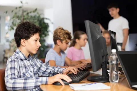 Boy student learning to work on computer in classroom Foto stock