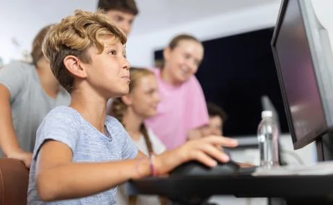 Boy student learning to work on computer in classroom Foto stock