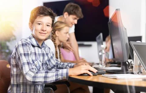 Boy student learning to work on computer in classroom Foto stock