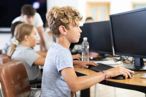 Boy student learning to work on computer in classroom Foto stock
