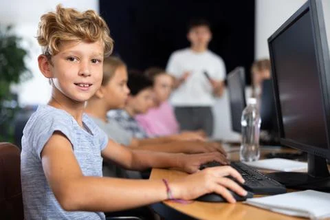 Boy student learning to work on computer in classroom Foto stock