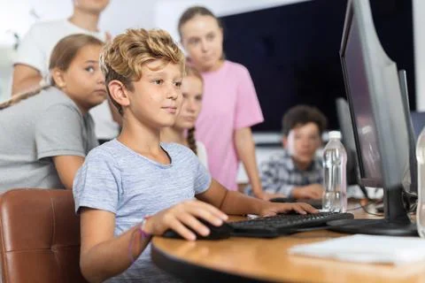Boy student learning to work on computer in classroom Foto stock