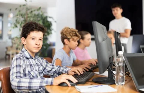 Boy student learning to work on computer in classroom Foto stock
