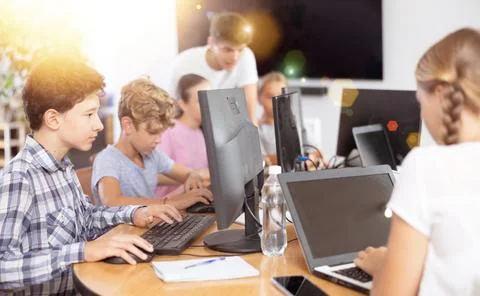 Boy student learning to work on computer in classroom Foto stock