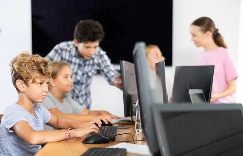 Boy student learning to work on computer in classroom Stock Photos