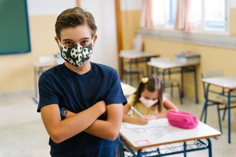 Boy student looking at camera in the class wearing a mask. during covid pandemic Stock Photos