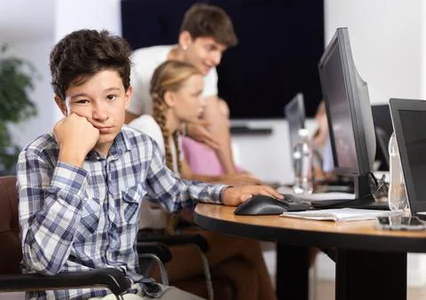 Boy student posing at computer in classroom Stock Photos
