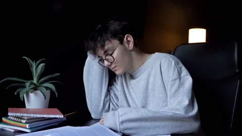 Boy student sitting at home with school books and papers doing homework. Stock Footage 232295995