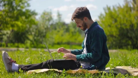 Boy student sitting in a nature while working on laptop Stock Footage 76488106