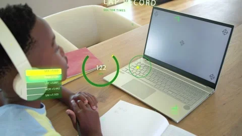 Boy student sitting at table viewing laptop starting HUD showing lap record Stock Footage 333351082