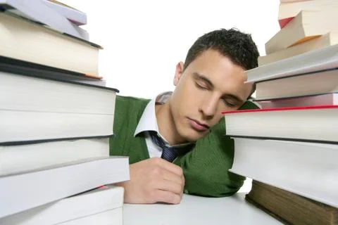 Boy student sleeping over stack books over desk Stock Photos