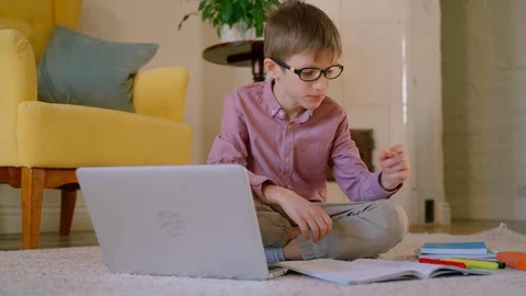 Boy student use internet on laptop at home write in book busy with online Stock Footage 128973209