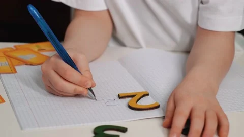 The boy studies numbers, draws and writes numbers, rejoices at success. The Stock Footage 230514916