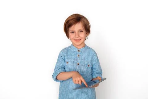 Boy studio standing isolated on grey browsing digital tablet looking camera Stock Photos