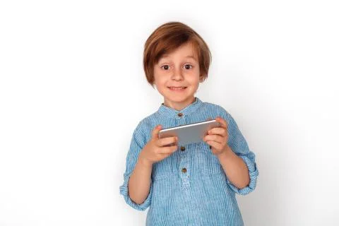 Boy studio standing isolated on grey watching video on smartphone looking camera Stock Photos