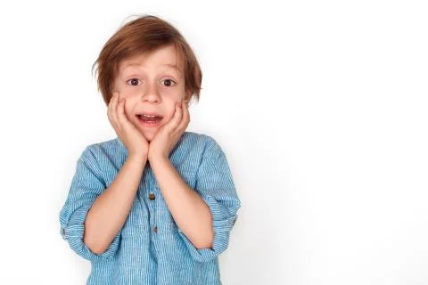 Boy studio standing isolated on grey touching face looking camera excited Stock Photos