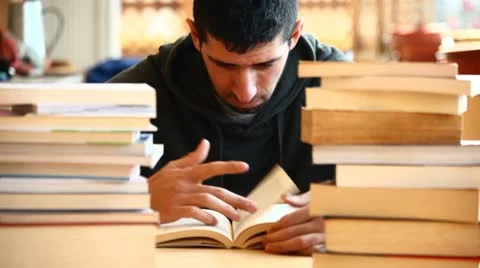 Boy studying among the books Stock Footage 10895458