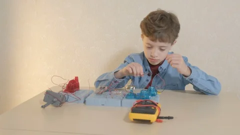 The boy studying electronics. Uses a digital multimeter and led strip Stock Footage 130107765