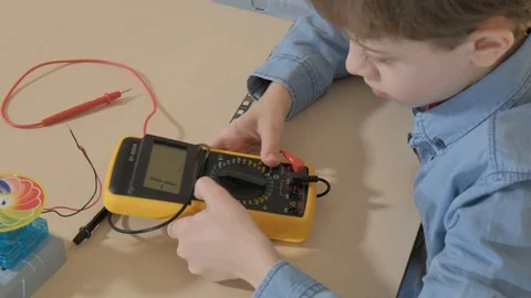 The boy studying electronics. Uses a digital multimeter and led strip Stock Footage 130108232
