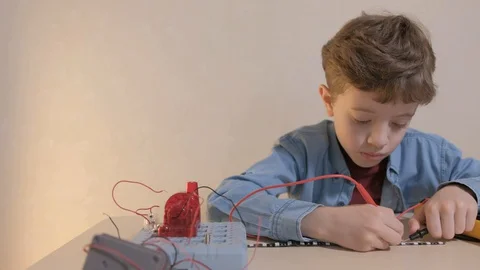 The boy studying electronics. Uses a digital multimeter and led strip Stock Footage 130108234