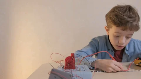 The boy studying electronics. Uses a digital multimeter and led strip Stock Footage 130108238