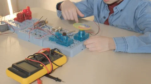 The boy studying electronics. Uses a digital multimeter and led strip Stock Footage 130108243